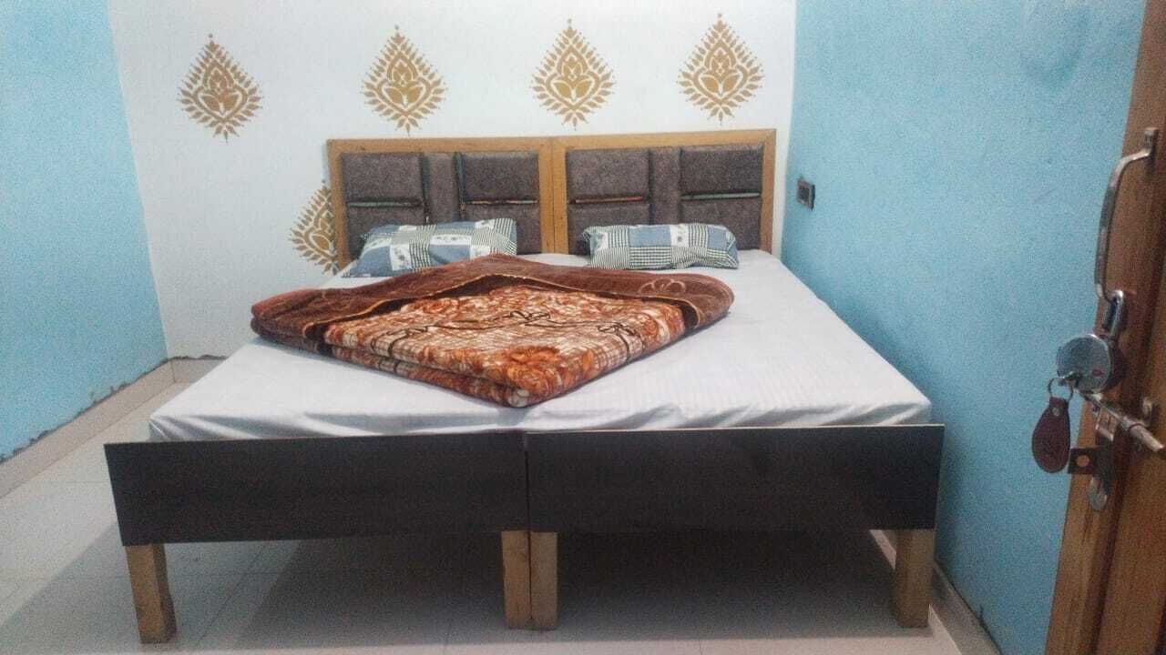 A bedroom with a bed, a wooden headboard, and a patterned blanket.