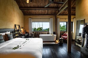 A bedroom with a large bed, a bathtub, a chair, and a mirror. - naked Castle  (Huzhou)