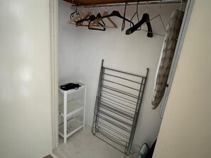 A small, white closet with a metal drying rack and a shelf holding a black item. - The Elden - No.18 (London)