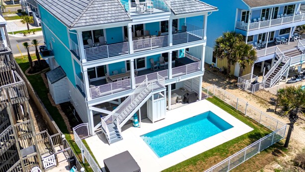 A multi-story hotel with a swimming pool, balconies, and a view of the surrounding area. - Brand-New Oceanfront Showstopper | 6 En-Suite Bedrooms, Pool, 2 Hot Tubs, Elevator (North Myrtle Beach)