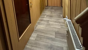 En hall med trädörrar, ett element och en taklampa.