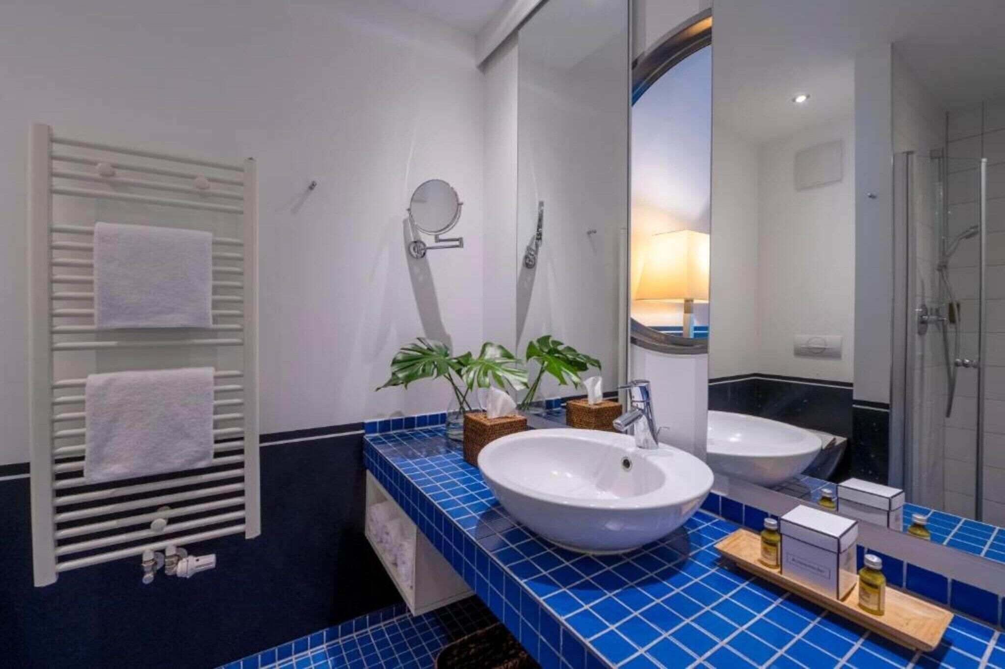 A bathroom with two sinks, a towel rack, a mirror, and a shower.