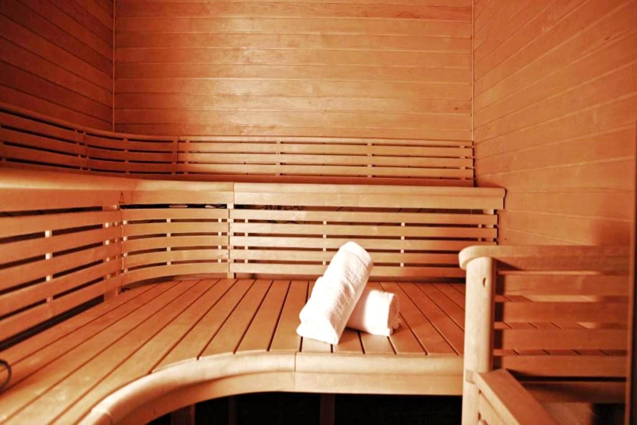 A sauna with wooden benches and benches, and a towel on the floor.