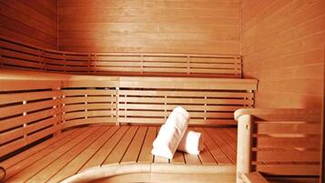 A sauna with wooden benches and benches, and a towel on the floor.