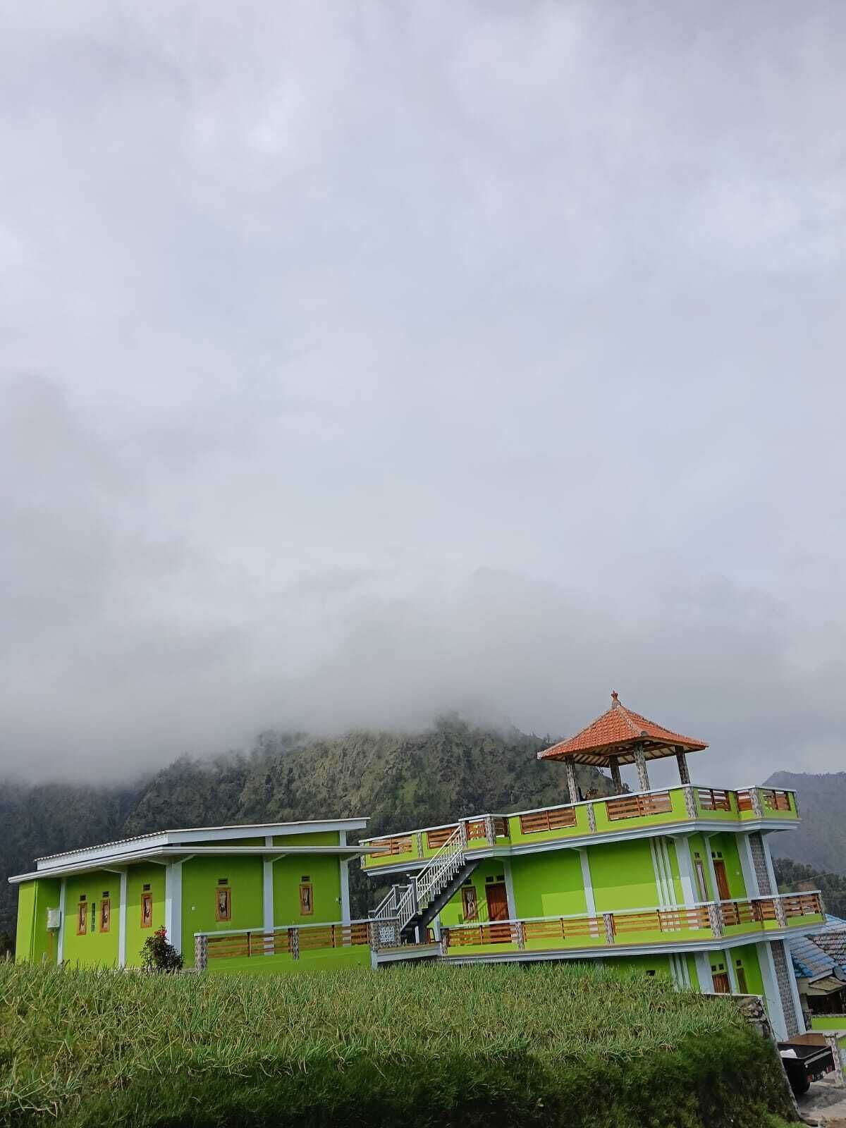 Un bâtiment à deux étages, doté d’une façade verte et d’un pavillon surmonté d’un toit rouge.