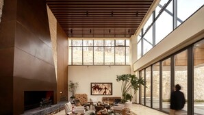 A spacious lobby with a fireplace, comfortable seating, and large windows offering views of the outdoors. - naked Home GRAND Ginkgo Valley (Xiaogan)