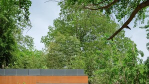 A modern building with a swimming pool, surrounded by lush greenery. - naked Home GRAND Ginkgo Valley (Xiaogan)
