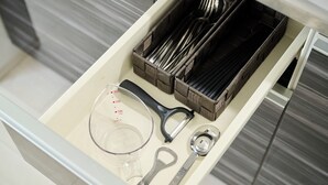 A kitchen drawer with utensils, a measuring cup, and a wine opener. - Gekkō Hakata Higashi (Fukuoka)