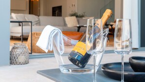 A bottle of champagne in a glass, two empty glasses, and a black bowl on a table. - Villa 'Dominica 10' with Sea View, Wi-Fi and Air Conditioning (Estepona)