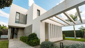 A modern house with a stone pathway, a covered patio, and a well-maintained garden. - Villa 'Dominica 10' with Sea View, Wi-Fi and Air Conditioning (Estepona)