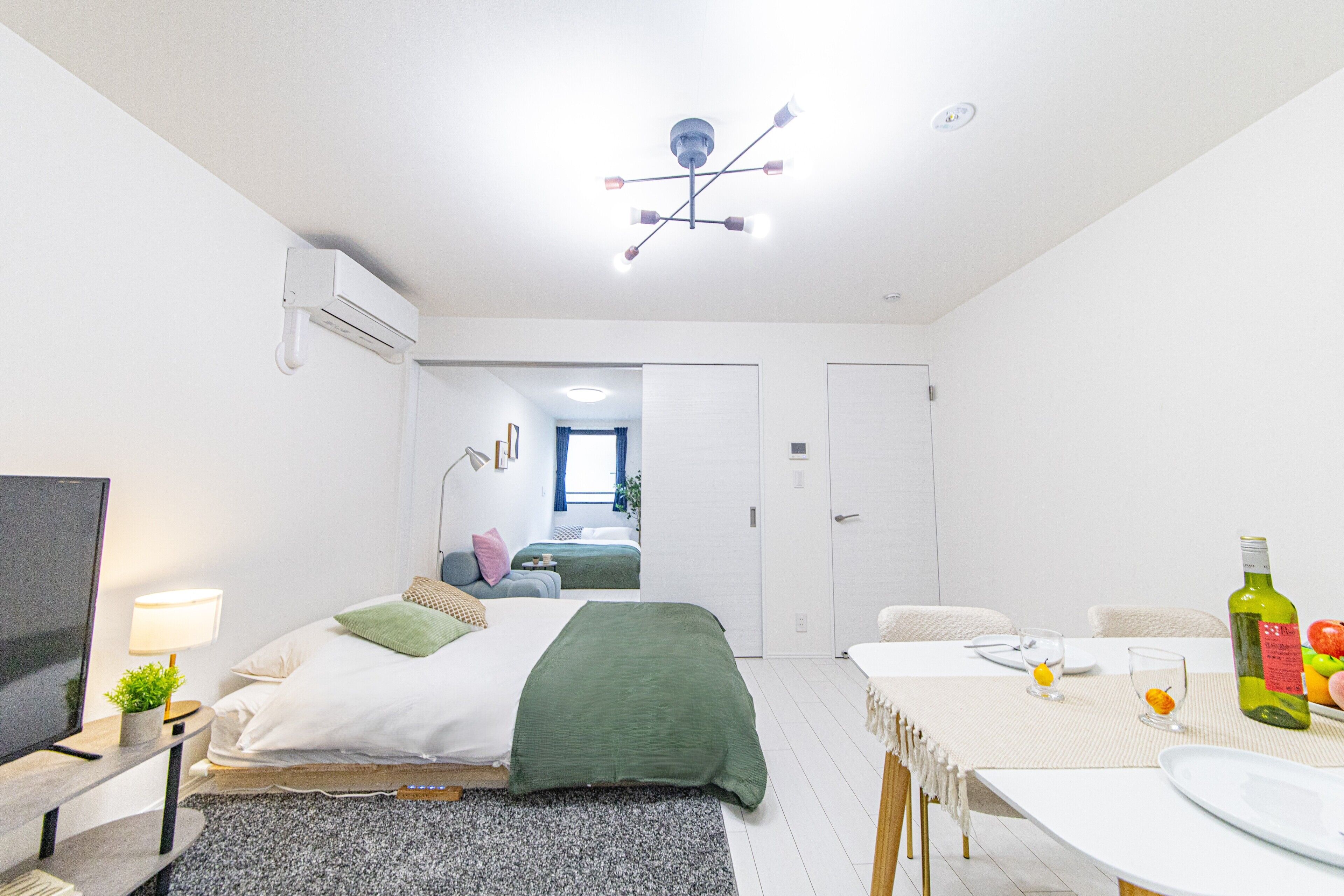 A modern bedroom with a bed, bedside table, lamp, and a television.