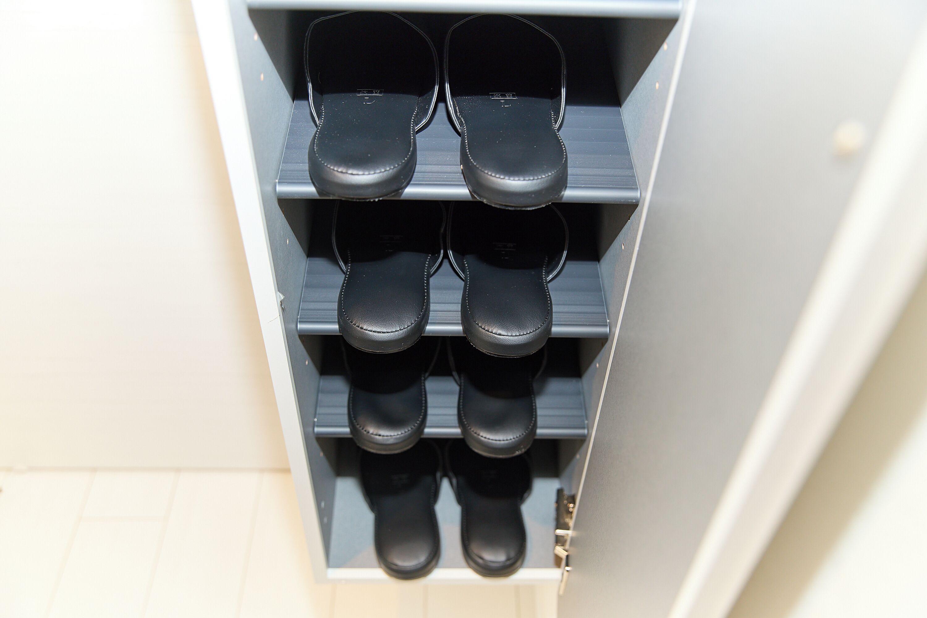 Un mobiletto per scarpe con diversi paia.