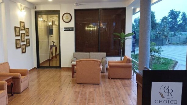 A reception area with a wooden floor, a reception desk, a clock, framed pictures on the wall, and a sign for Choice Resort.