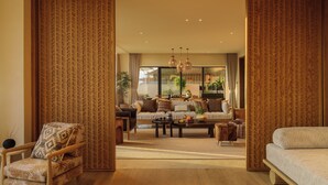 A spacious living area with a sofa set, a coffee table, and a patterned chair. - bynaked Boluo Huizhou (Huizhou)