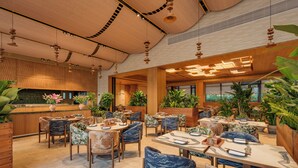 A spacious indoor dining area with multiple tables and chairs, wooden accents, and potted plants. - bynaked Boluo Huizhou (Huizhou)