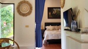 A bedroom with a bed, a TV, and a window with curtains. - White lotus house (Maret)
