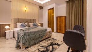 Une chambre à coucher moderne avec un lit, une table de chevet, une lampe et un ventilateur de plafond.