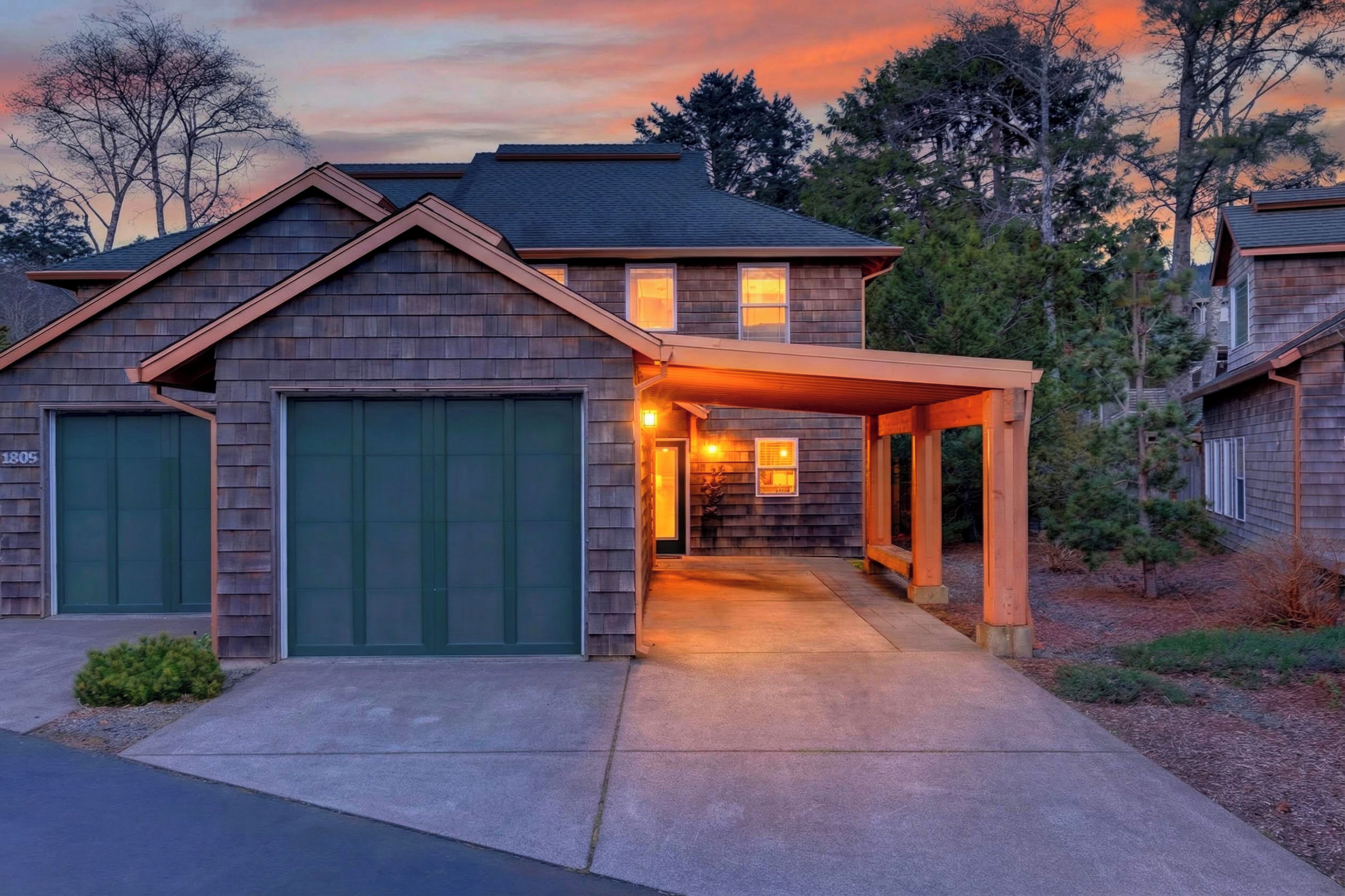 Une maison à deux étages avec un porche abrité, un garage et une allée.