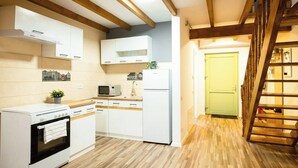 A modern kitchen with white cabinets, a built-in oven, a microwave, and a refrigerator. - Nest in Middle Olt Town Near Cathedral - Libertății - Iulius Mall (Timișoara)