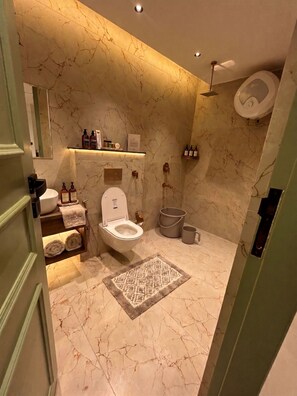 A bathroom with a toilet, sink, and shower area. - Hotel Central Park Inn (Dehradun)