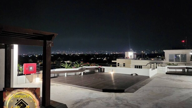 Terraza en la azotea con vistas a la ciudad de noche.
