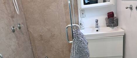 A bathroom with a shower, sink, and toilet.
