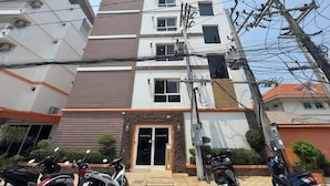 Un edificio a più piani con un ingresso centrale, circondato da motociclette parcheggiate.