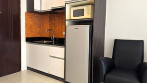 A compact kitchen with a microwave, refrigerator, and sink. - Comfortable Pool-View Studio with Balcony - Pratumnak, Pattaya (Muang Pattaya)