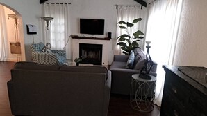 A living room with a fireplace, a large sofa, a smaller sofa, and a plant. - 3 bedroom plus 2 baths in Beverly hills (Beverly Hills)