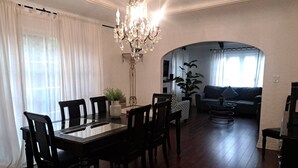 A dining area with a chandelier, a dining table, and chairs. There is a sofa and a coffee table in the background. - 3 bedroom plus 2 baths in Beverly hills (Beverly Hills)
