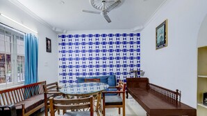A dining area with a glass table surrounded by wooden chairs and benches. - Collection O Sunrise Point Serenity Beach (Vanur)