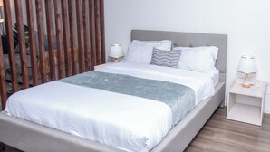 Une chambre à coucher moderne avec un lit, des tables de chevet et une cloison en bois.