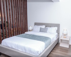 Ein modernes Schlafzimmer mit einem Bett, Nachttischen und einer Holzwand.