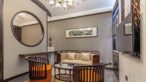 Una sala de estar moderna con un sofá, dos sillones, una mesa de centro y un espejo grande.