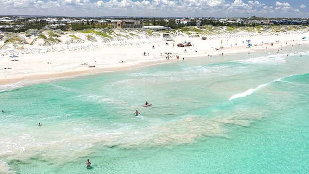 A beach with clear turquoise water, white sand, and a few people swimming and walking. - Relaxing three bedroom Beach House on the coast. Close to cafes and golf course. (Secret Harbour)
