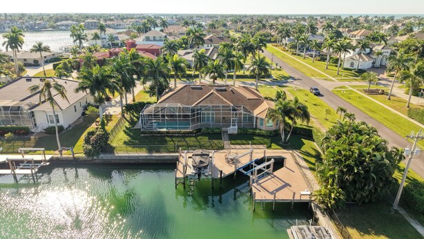 An aerial view of a residential area with houses, a swimming pool, and a dock. - Waterfront, Private Pool, Close to Beaches, Best of Marco! (Marco Island)