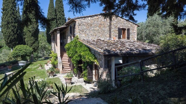 A stone house with a stone staircase leading to a wooden door, surrounded by greenery and trees. - Podere le Lune with Pool, San Gimignano (San Gimignano)
