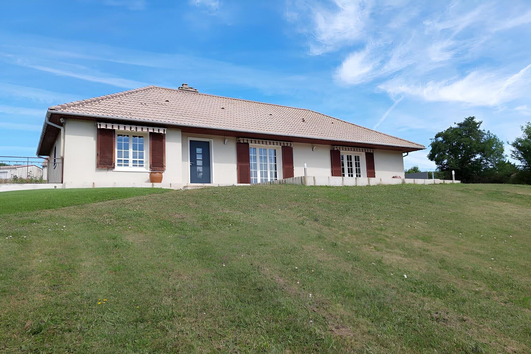 A single-story building with a tiled roof, a flat facade, and a small front porch.