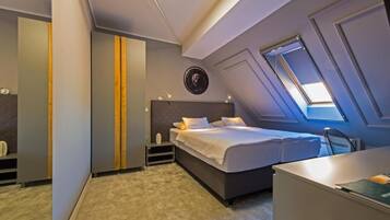 Un dormitorio moderno con una cama grande, un escritorio y un armario.