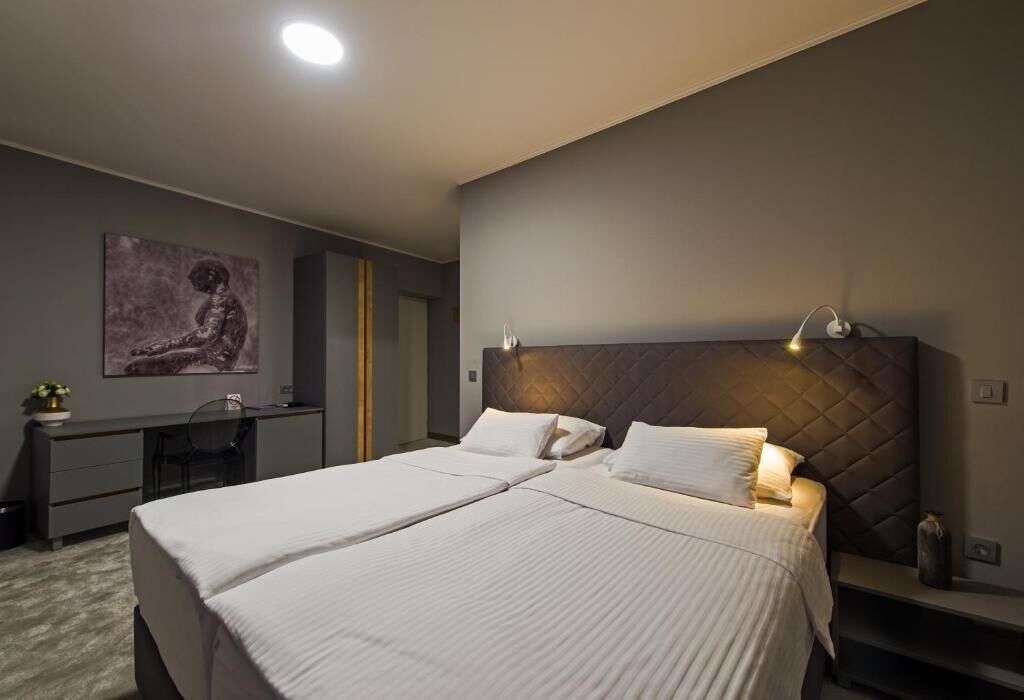 Een moderne hotelkamer met een groot bed, een bureau en een stoel.