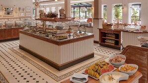 A buffet area with multiple food stations, a central serving counter, and a variety of dishes displayed. - Sunday Resort Rügen Manor Suite (Sagard)