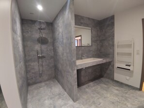 Een douche, een haardroger, handdoeken, toiletpapier