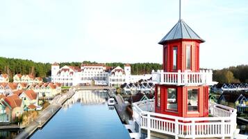 A canal with a red and white tower, surrounded by traditional houses.