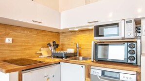 Eine kompakte Küche mit Mikrowelle, Toaster und Geschirrspüler.