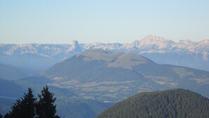 A mountainous landscape with a prominent peak and a small settlement in the valley. - Apartment in Chamrousse Near Cable Car (Chamrousse)