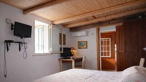 A bedroom with a bed, a desk, a chair, a television, and a wardrobe. - Laura's Little Houses: Mondello 1 (Palermo)