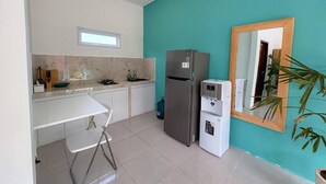 A compact kitchen with white cabinets, a stainless steel refrigerator, a compact dishwasher, and a teal accent wall. - Canggu 1 BR Private Pool Villa Polly (Canggu)