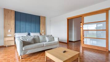Una sala de estar moderna con un sofá, una mesa de centro y un ventanal corredero que da a un área exterior.