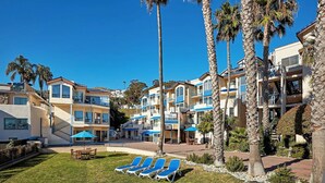 A resort with multiple-story buildings, outdoor seating areas, and palm trees. - Enjoy Stunning Avalon Views at this Private Boutique Escape | 4 Units (Avalon)