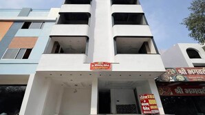 Ein mehrstöckiges Gebäude mit flacher Fassade, mehreren Balkonen und einem Schild, das ein Hotel und Restaurant bewirbt.